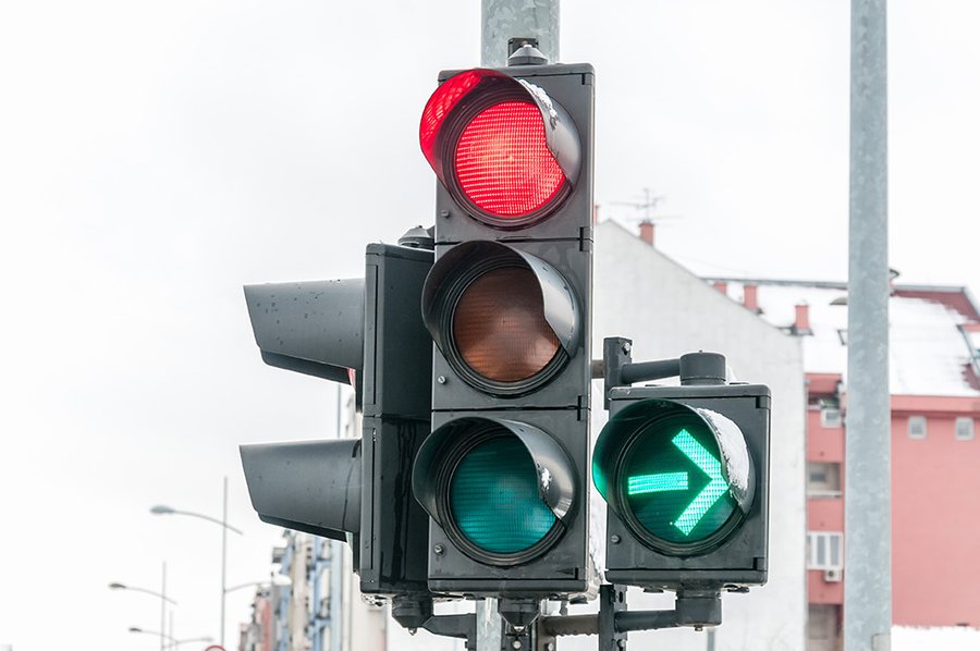 Semáforo en luz roja junto a una flecha verde hacia la derecha